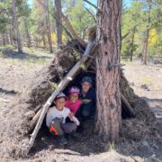 Three kiddos in their debris shelter