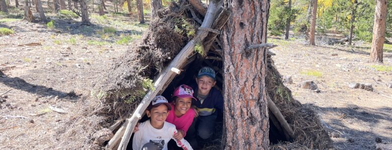 Three kiddos in their debris shelter