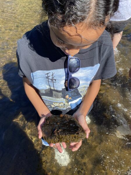 An AXL student shows what she found in the river!