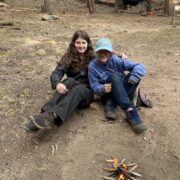 Two students who have successfully built a small fire