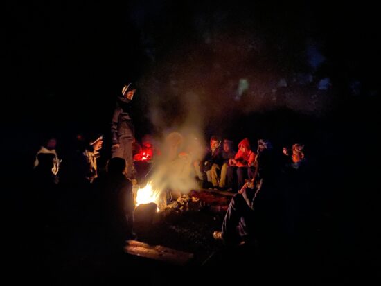 AXL group relaxes by the fire at night at Calwood. 
