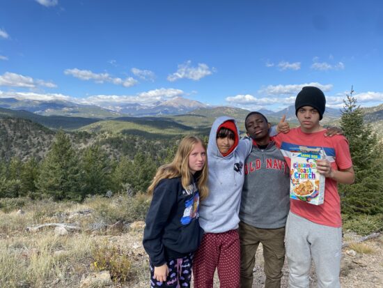 Four AXL students pose in front of Long View with a box of cinnamon toast crunch. 