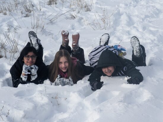 Three AXL students playing in the snow