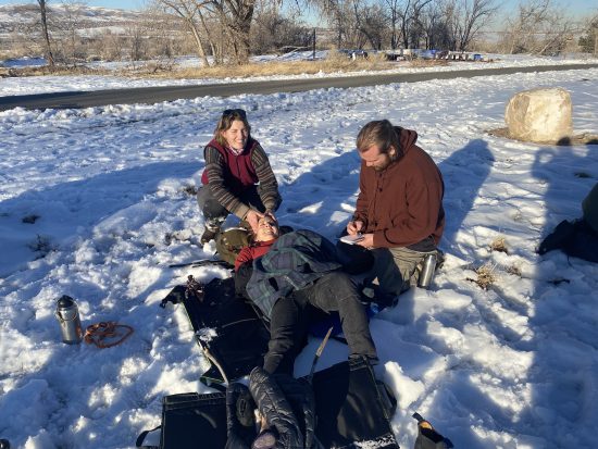 Winter training with Global Emergency Medics. Two instructors treat a patient.