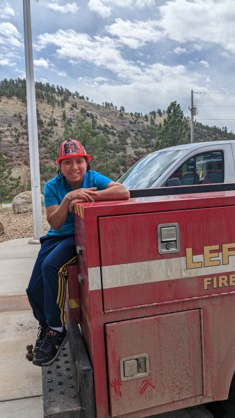 A student wearing a firefighter helmet at Left Hand Fire Station.