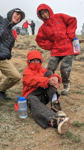 Students sitting in the snow on their spring overnightl