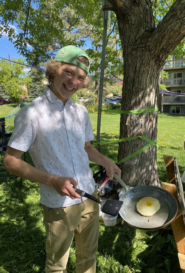 boy flipping a pancake outdoors