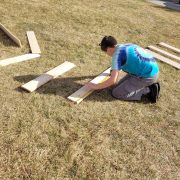 An Angevine Middle School student measures lumber to help build a Gaga Ball pit at their school