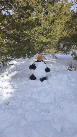 Ignacio Precadio Gutierrez holds a giant snowball he constructed; he used it as a shelter during the snow-war during the 2/2 snowshoe trip. Photo courtesy of Erin Angel.