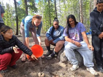 An instructor demonstrates the effect of water on the land on this trip focused on learning about Colorado's water.