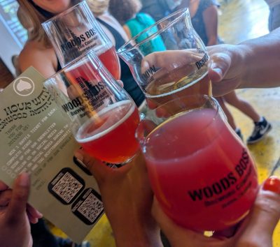 Community members raise glasses of beer and other drinks at Woods Boss Brewing to celebrate Cottonwood Institute's programs.
