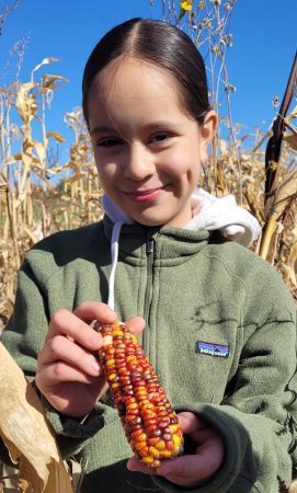 A student on the LEO program shows off some corn she enjoyed harvesting at Miller Farms.