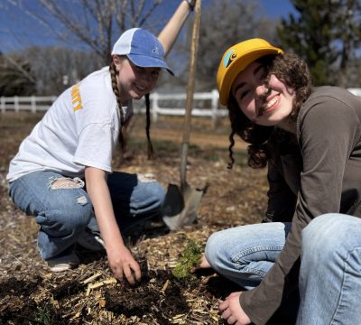 Two CAP students smile and post while doing service work at Ollin Farms. The top 10 ways to donate will support our CAP programs.