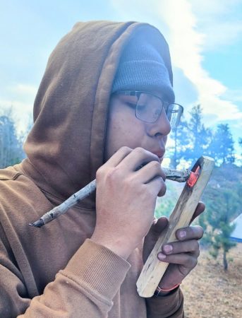 One Changemaker student gently blows on the coal that is being used to create a coal-burned spoon during the Taylor Mountain backpacking trip.