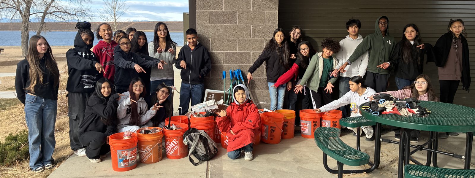 AXL 8th graders pose with their orange buckets that they used for their litter cleanup and microplastics hunt.