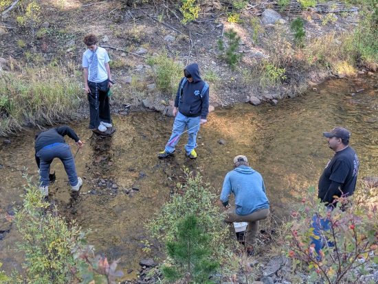 Angevine students show curiosity about invertebrates as they wade into a creek during their overnight CAP trip.
