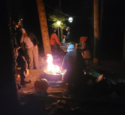 Cottonwood Alumni cook over the fire during their Solstice Hike evening event.