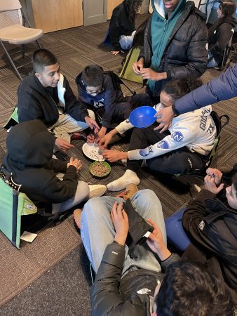 AXL students gather around bowls of seeds as they prepare native wildflower seeds for spring planting on the Cal-Wood property.