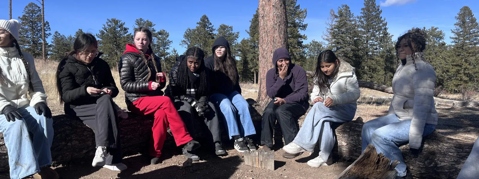AXL 8th graders sit outside on benches at Cal-Wood during their winter overnight.
