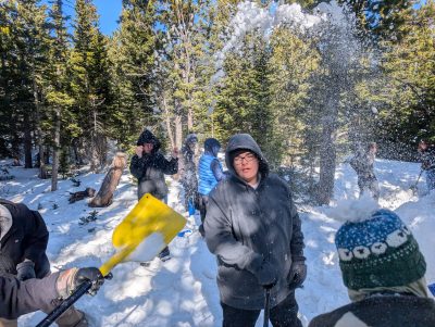 AMS students fling snow while building a quinzee at Brainard Lake during their CAP field day.
