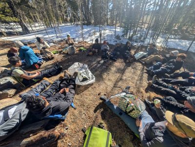 AMS students gather in a circle after quinzee construction.
