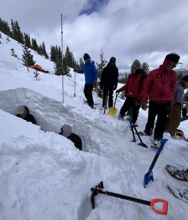 Apex students dig snow pits during their climate literacy-focused trip.