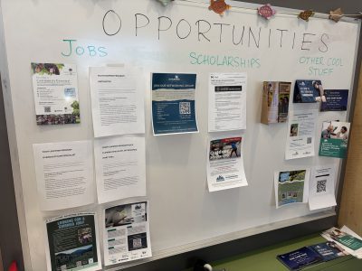 A white board displays flyers showing opportunities such as jobs and scholarships at the Career Bloom Career Day event.