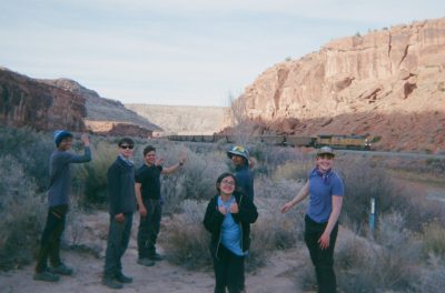 Students point to a train they see going through the canyon where they were backpacking.