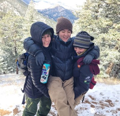 Two Changemakers Alumni try to lift up another during their spring break hike in the snow.