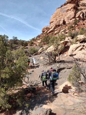 Students walk on a trail during their canyon backpacking trip with Peak to Peak Charter School.