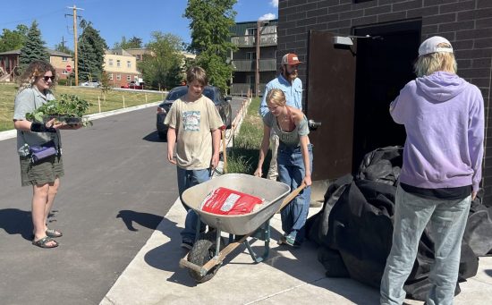 Students take materials out of the farm shed as they help with the farm action project.