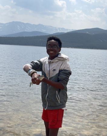 A Cottonwood Water Program student shows off a fish he caught.