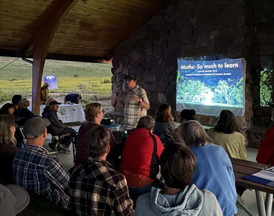 Mothapalooza attendees watch a presentation about nocturnal pollinators.