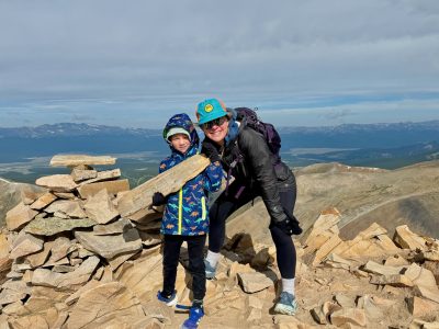 Cottonwood Board member Alyssa poses on the top of a mountain with her child.