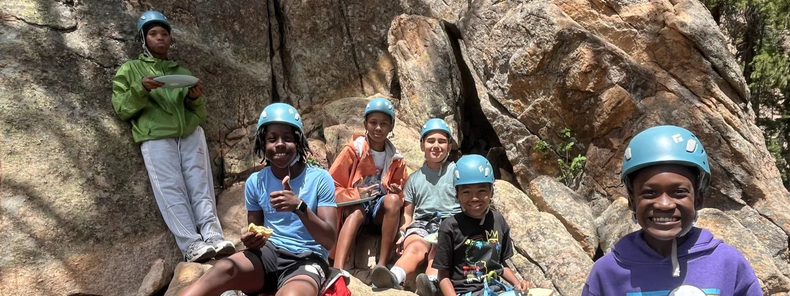 Sims-Fayola students pose near the rocks where they were climbing on the trip where nature-based learning came to life.