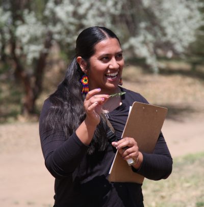 Harmony, of the staff members taking on a new role soon, shows an edible plant that was found in the area.