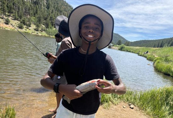 One Sims-Fayola student shows off a fish he caught during the outdoor program designed to help nature-based learning come to life.