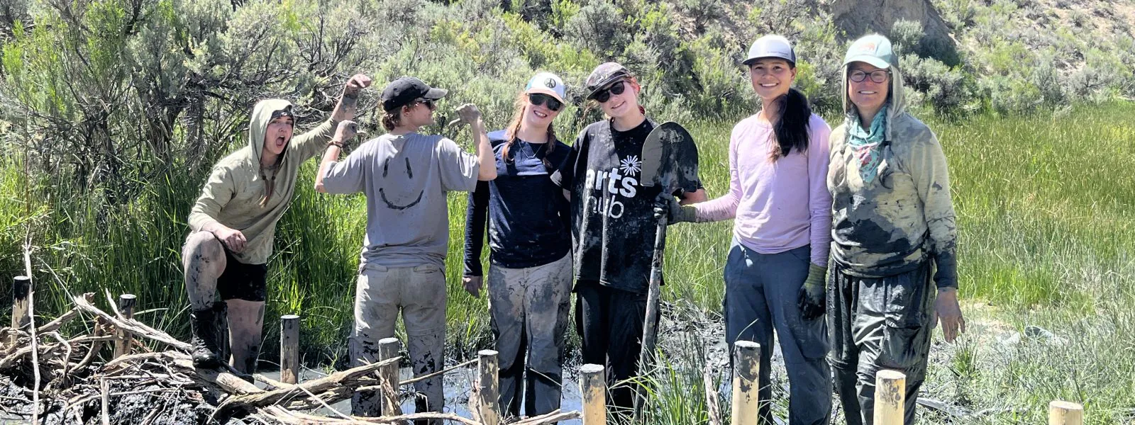 Students pose with their tools while they take a break from their restoration efforts on their Changemakers adventure.