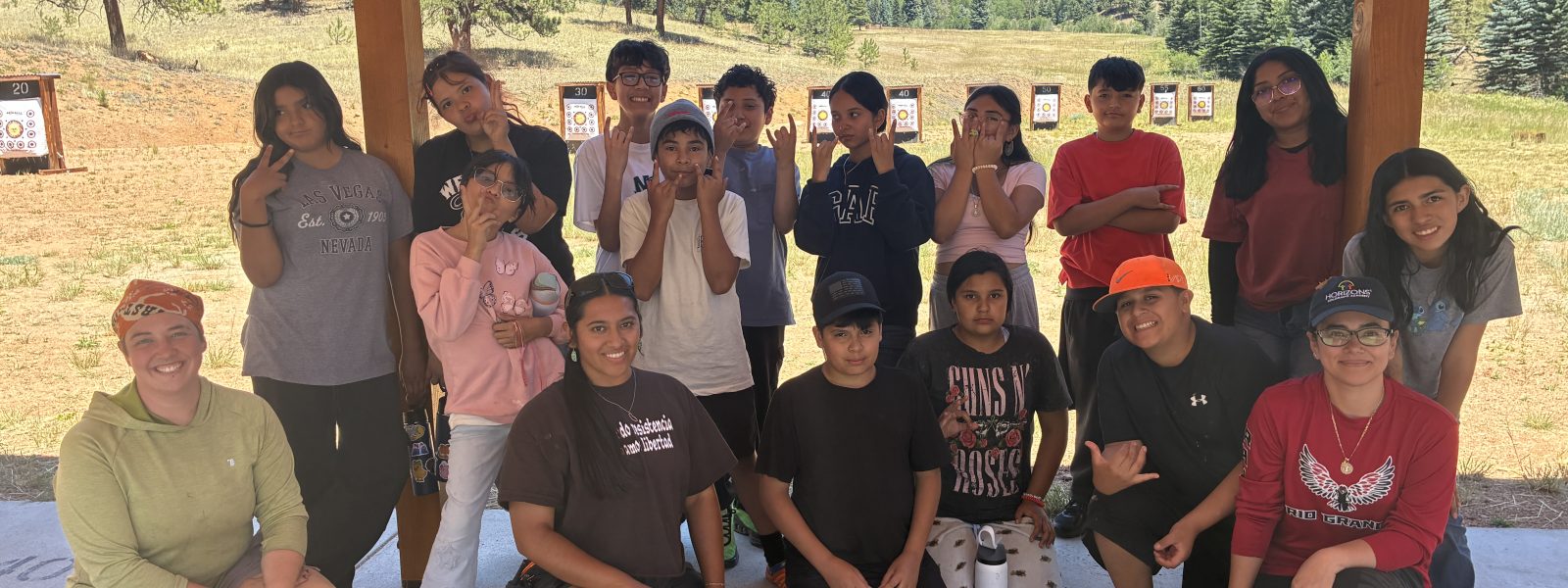 Students and Instructors pose in front of the archery targets.