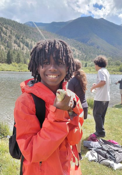 One student poses with the fish he caught in front of a mountain backdrop during the 4-day hydrological adventure.