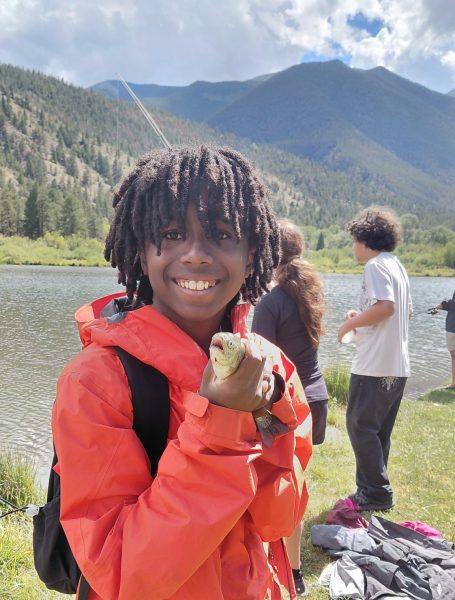 One student poses with the fish he caught in front of a mountain backdrop during the 4-day hydrological adventure.