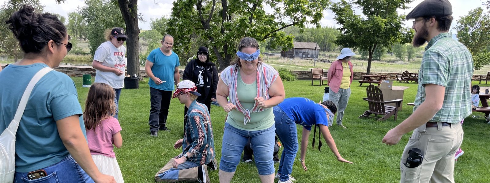 People at the ancestral skills workshop at Sandstone Ranch play games on the grass.