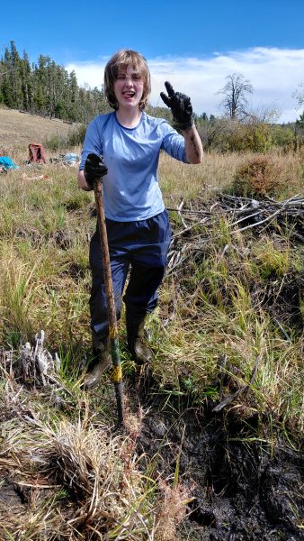 One Changemaker student poses with a shovel during the Greenback restorations work.