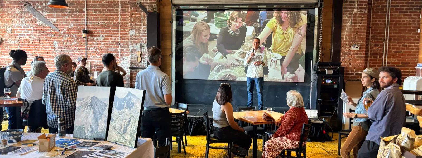 Ford Church, Founder and Executive Director of Cottonwood Institute talks on stage to attendees of the happy hour and community networking event.