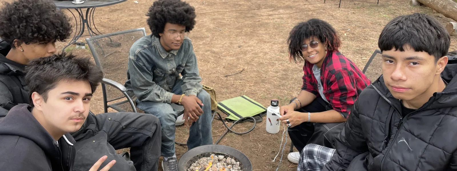 Students sit around the campfire on the Staunton camping trip.
